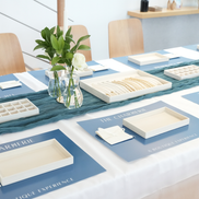 Decorative table setting with place cards, candles, and floral arrangements in a modern indoor setting for charms jewelry making workshop in duab for EID 2026